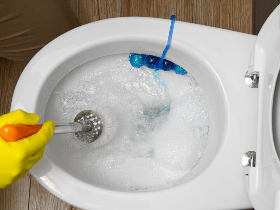 Man cleaning overflowing broken toilet. clogged toilet.